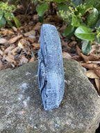 Side view of a 22nice4me Garden Statues concrete angel memorial plaque with a weathered grey finish in a garden.