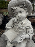 22nice4me Garden Statues concrete boy statue wearing a hat and reading a book while sitting on a rustic bench