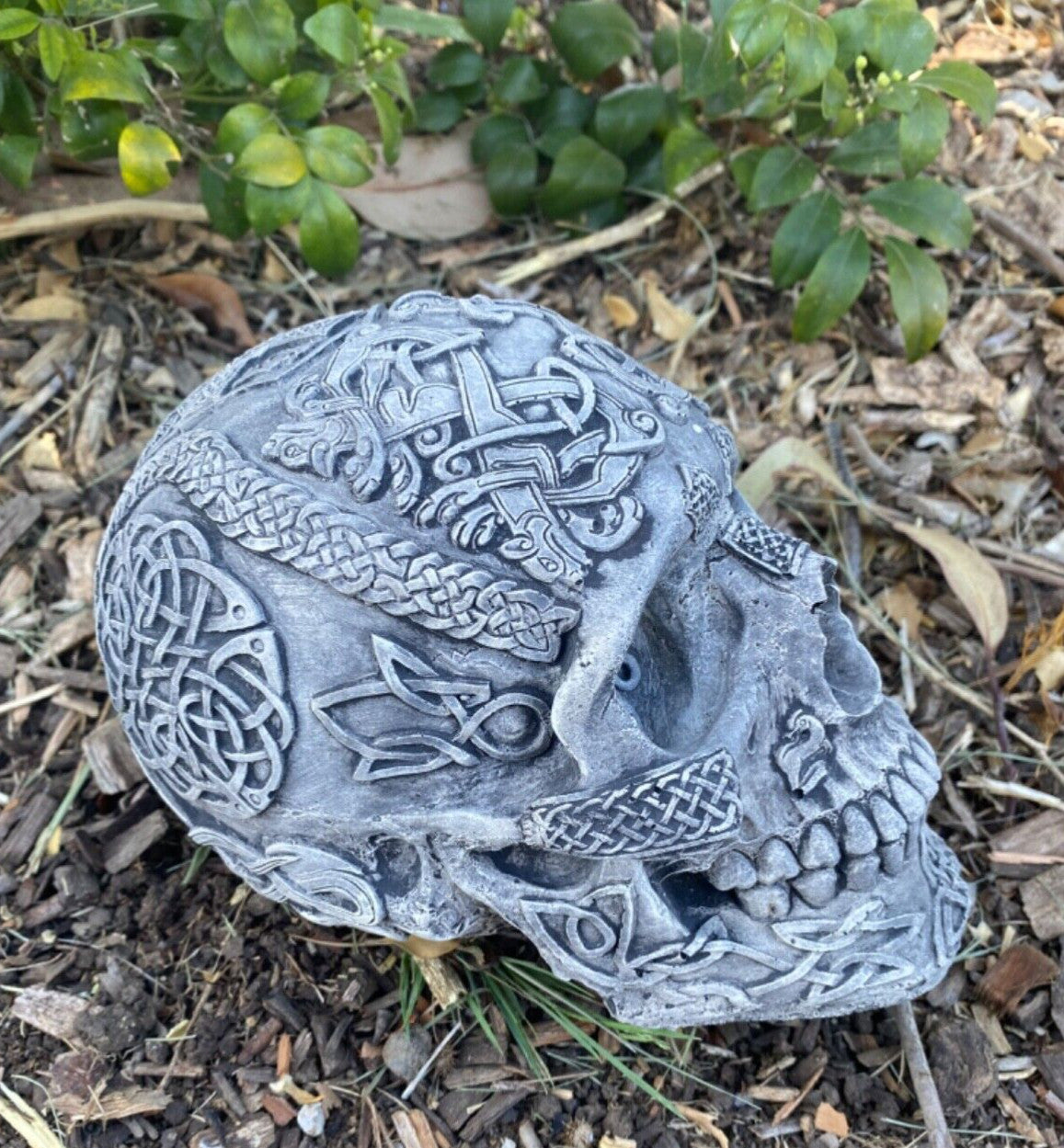 22nice4me Garden Statues concrete skull ornament with intricate Celtic knotwork designs in a garden setting