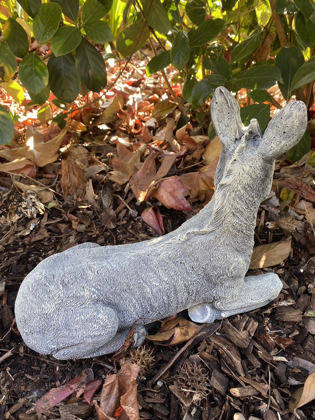 22nice4me Garden Statues concrete donkey ornament in a lying pose with a textured grey finish in a garden setting