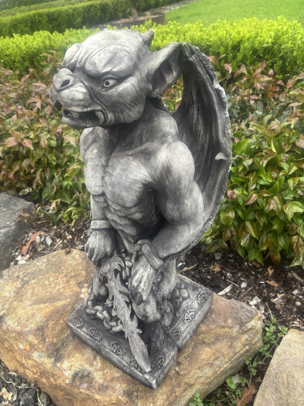 22nice4me Garden Statues concrete gargoyle with sword, featuring detailed gothic design on a stone base in a garden.