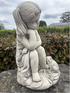 22nice4me Garden Statues concrete girl sitting with a frog, featuring a weathered grey stone finish in a garden.