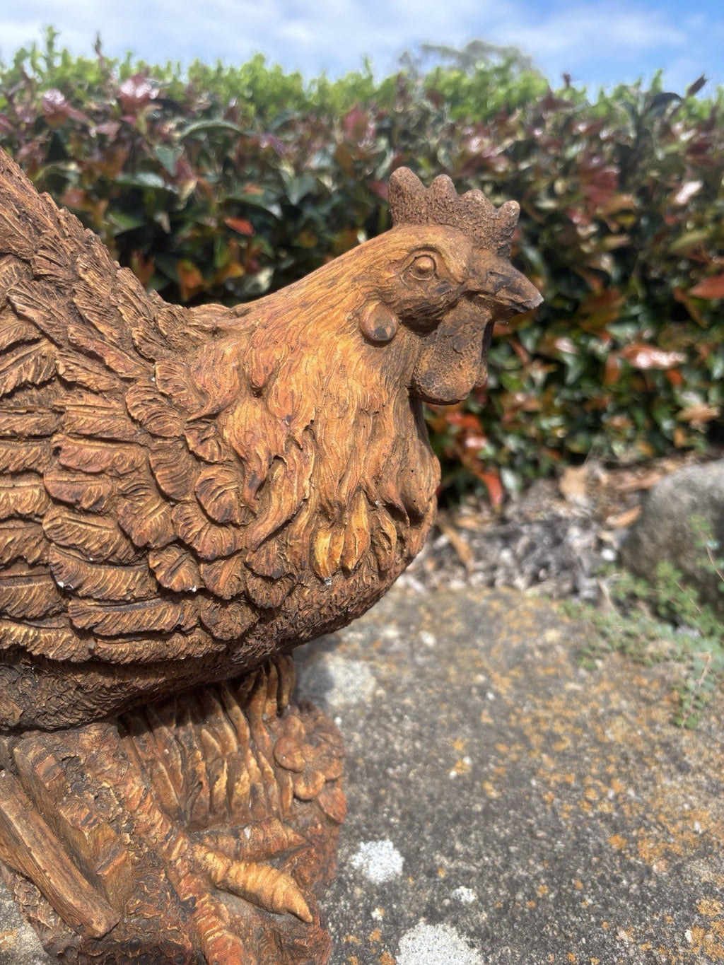 22nice4me Garden Statues concrete hen ornament with a detailed rustic rust finish on a tree-stump base in a garden