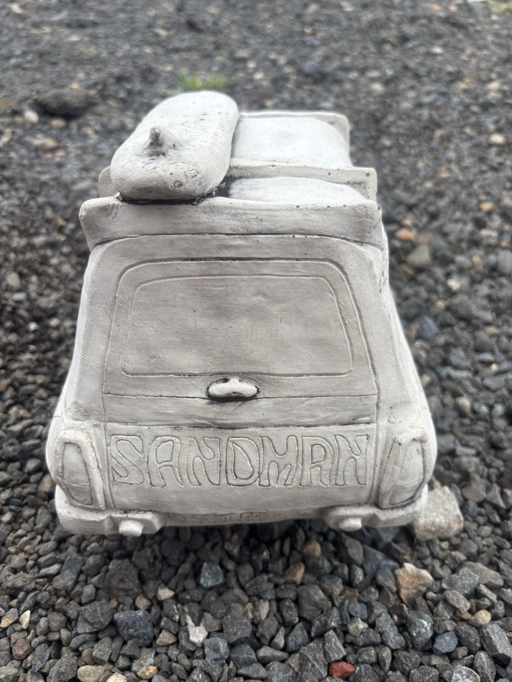 22nice4me Garden Statues concrete Sandman panel van ornament with surfboard detail, rear view on gravel surface.