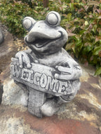 22nice4me Garden Statues concrete frog ornament with a weathered grey finish holding a Welcome sign in a garden