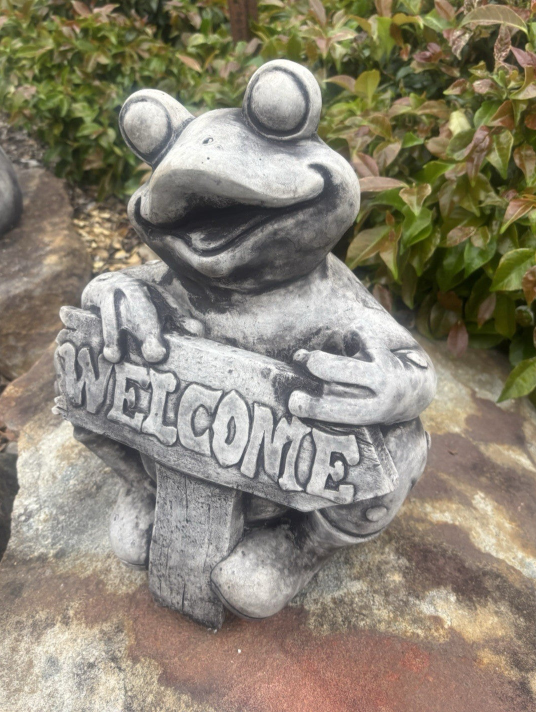 22nice4me Garden Statues concrete frog ornament with a weathered grey finish holding a Welcome sign in a garden
