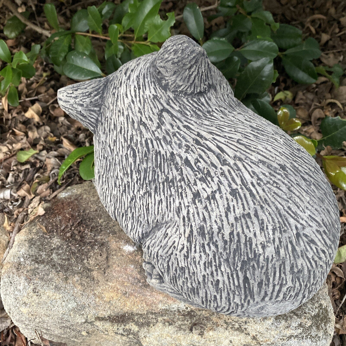 22nice4me Garden Statues Australian wombat ornament made of textured grey concrete sitting in a garden setting