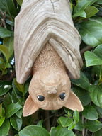 22nice4me Garden Statues hanging bat ornament made of hand-painted concrete nestled in green garden foliage
