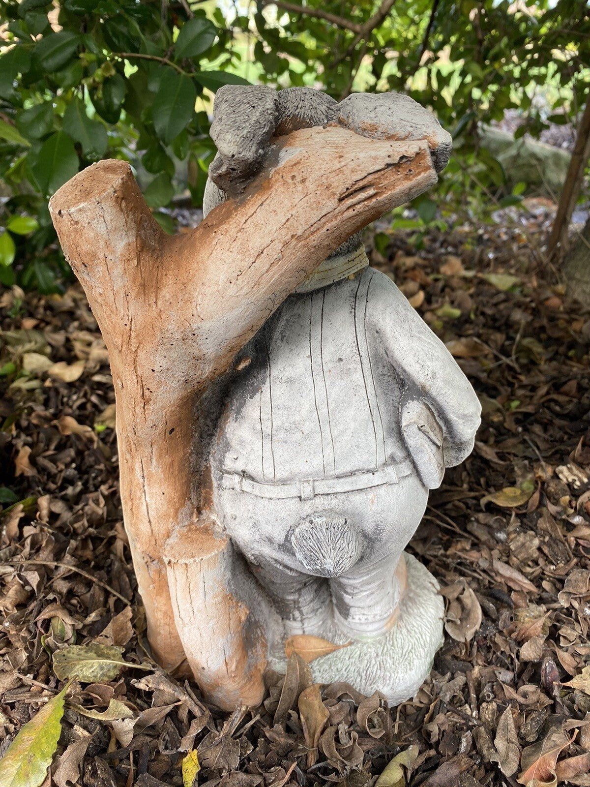 22nice4me Garden Statues Willow Father Rabbit concrete statue in a garden setting, back view showing tree trunk detail.