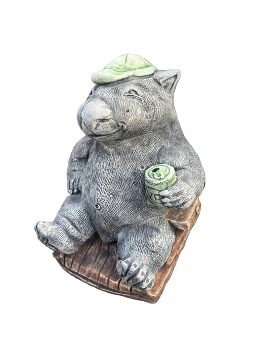 Wombat with a VB concrete garden statue displayed in a landscaped Australian garden amongst flowers and greenery
