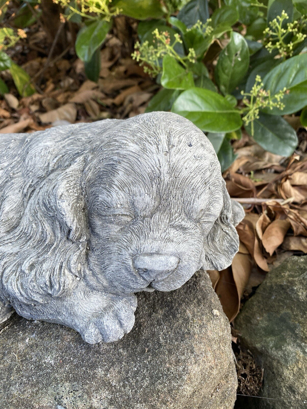 Close up detail of concrete pug garden statue textured cement finish