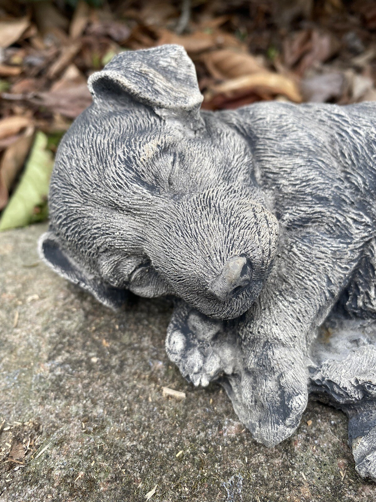 Close up detail of concrete jack russell garden statue textured cement finish