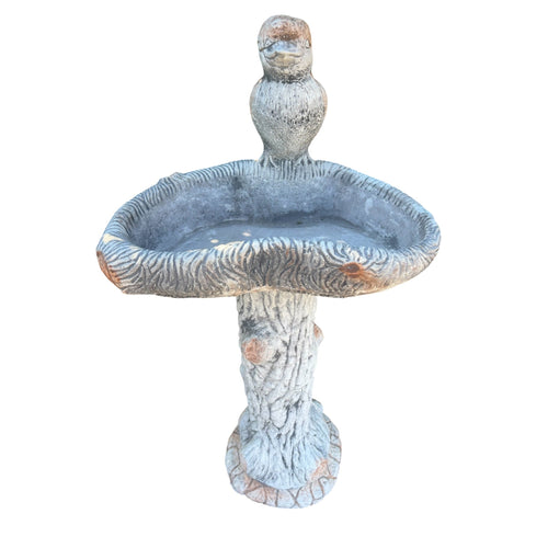 large concrete bird bath with a detailed kookaburra figure on a rustic tree-style pedestal