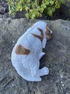 resin Cavalier King Charles Spaniel ornament in a relaxed laying pose on a stone surface